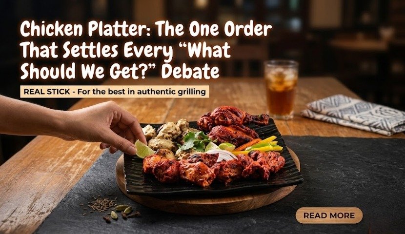 Chicken platter on a wooden board with grilled chicken, vegetables, and a hand reaching to pick a piece; coffee tab and napkin in the background.