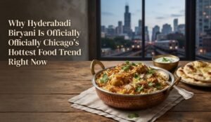 Copper bowl of Hyderabadi biryani on a wooden table with a city skyline in the background; article title about Chicago’s hottest food trend right now.