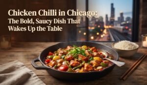 Chicken chili in a cast-iron skillet with peppers on a wooden table; rice bowl beside and a city skyline in the background.